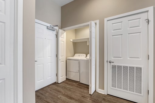 a laundry room with a washer and dryer and a closet with a door