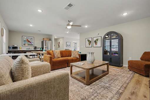 A living room with a brown couch, a coffee table, and a rug.