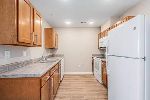 A kitchen with wooden cabinets and a white refrigerator.
