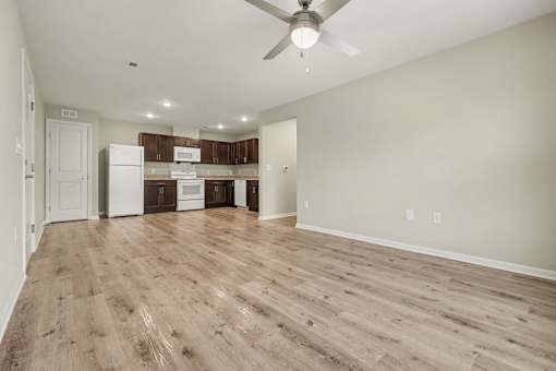 A room with a ceiling fan and wooden flooring.