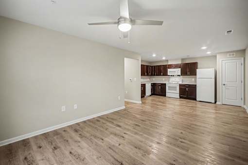 A room with a ceiling fan and wooden flooring.