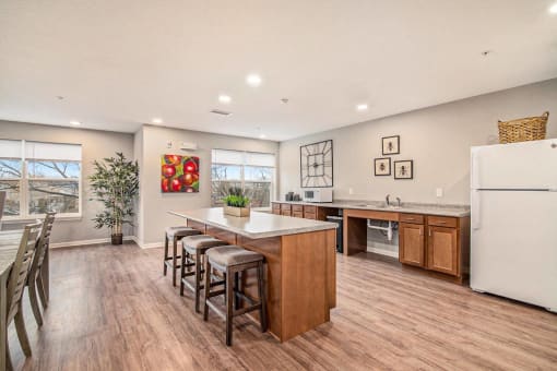 a kitchen with a center island and a bar with stools
