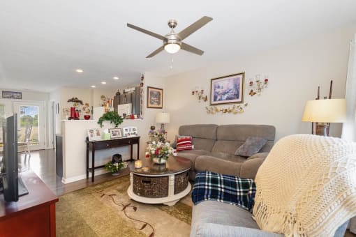 a living room filled with furniture and a ceiling fan