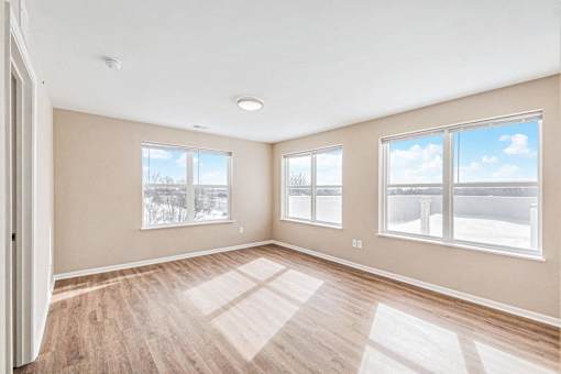 A room with a large window and a wooden floor.