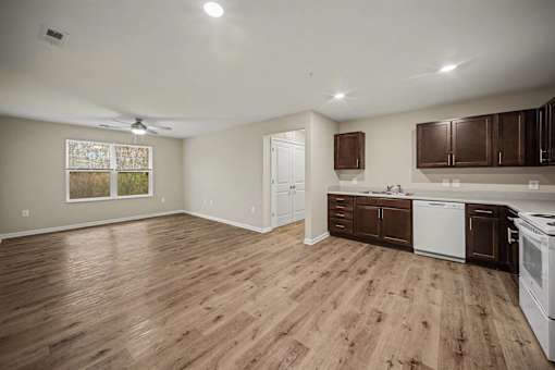A kitchen with wooden floors and white appliances.
