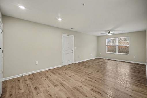 A room with wooden flooring and a ceiling fan.