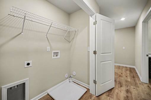 A white door is in a room with a white wall and a white mat on the floor.