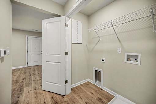 A room with a white door and a shelf on the wall.