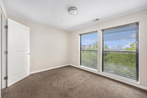 a room with a large window and a door and carpet
