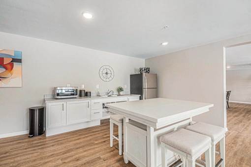 A kitchen with a white table and chairs.