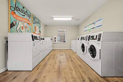 Laundry room with washers and dryers and a mural on the wall.
