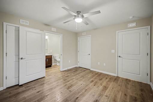 A room with a ceiling fan and wooden floors.