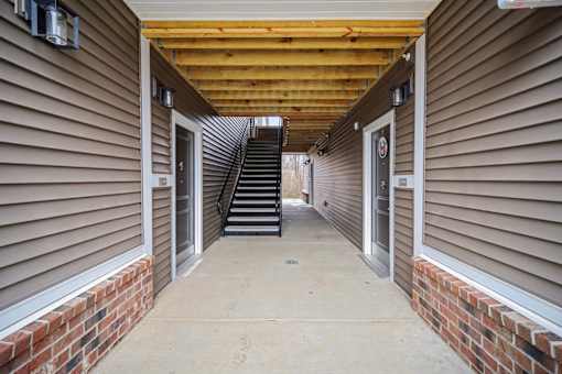 A long hallway with a staircase in the middle.