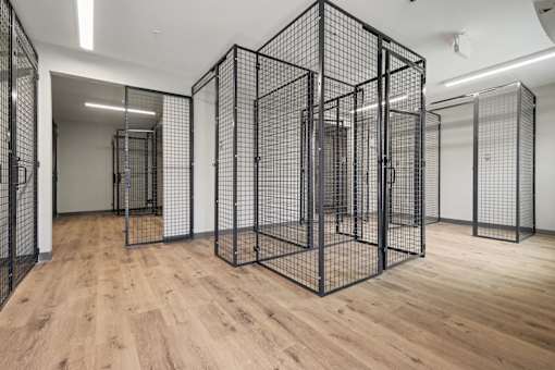 A room with wooden floors and a large black wireframe cube structure.