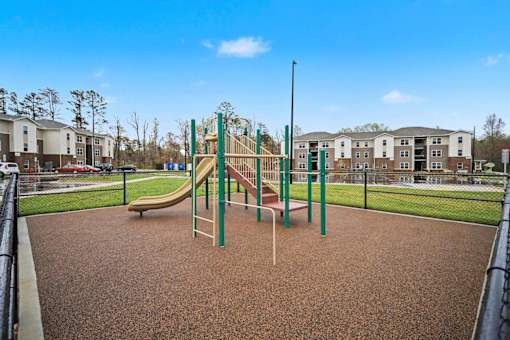 A playground with a slide and a green pole.