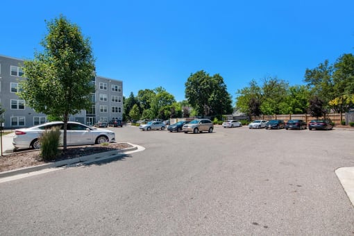 a parking lot with cars in front of an apartment building
