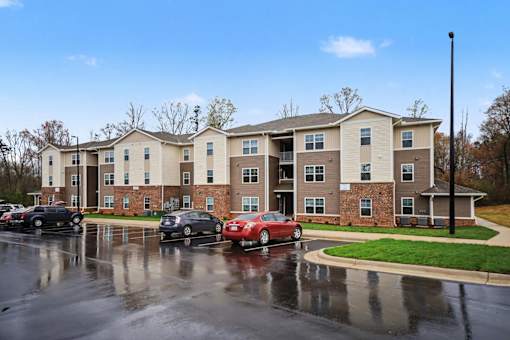 Apartment complex with cars parked in front.