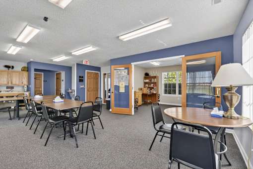 A room with tables and chairs and a blue wall.