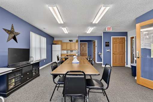 A conference room with a long table and chairs.