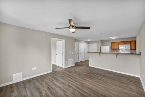 a living room and kitchen with a ceiling fan