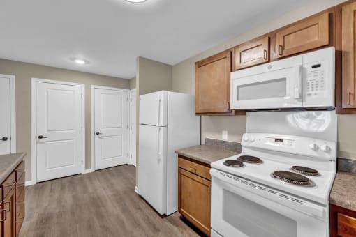 a kitchen with white appliances and wooden cabinets
