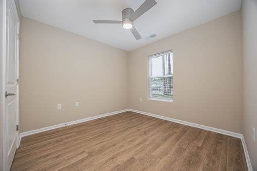 A room with a ceiling fan and a window.
