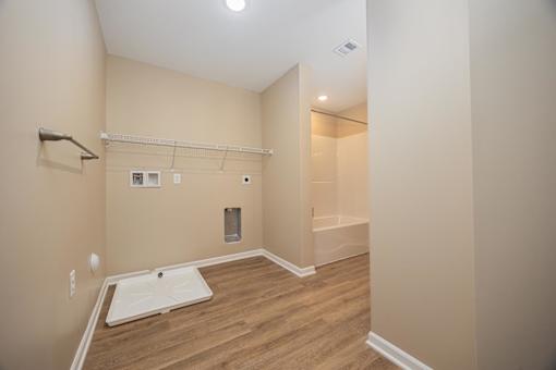 A bathroom with a white sink and wooden floor.