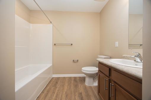 A bathroom with a toilet, sink, and bathtub.