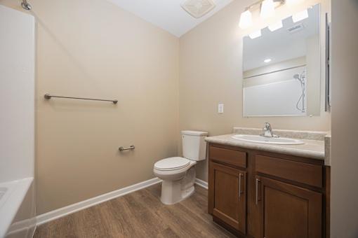 A bathroom with a toilet, sink, and a mirror.