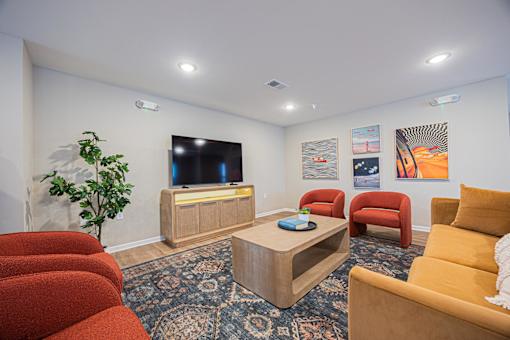 A living room with a red couch, a wooden coffee table, and a television.