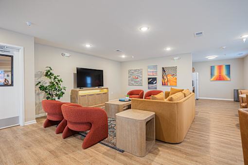 A living room with a red chair and a brown sofa.