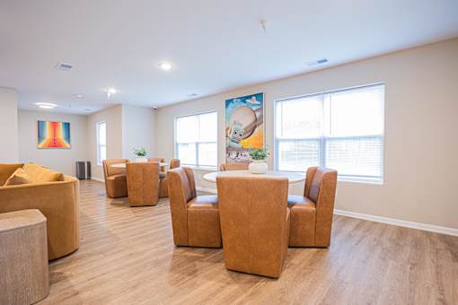 A room with brown chairs and a painting on the wall.