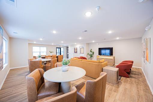 A modern living room with a white table and brown chairs.