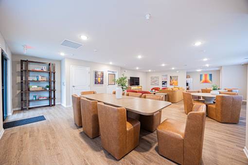 A conference room with a long table surrounded by chairs.