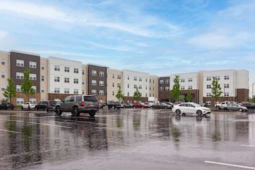 A parking lot with cars and a building in the background.