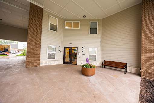 A building with a bench and a planter in front of it.