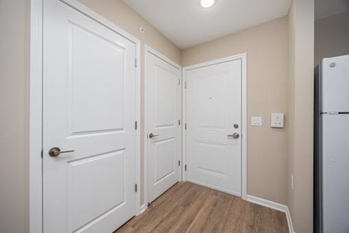 A white door is on the left and a white door with a handle is on the right.