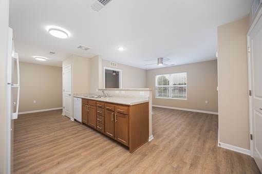A kitchen with wooden floors and white appliances.