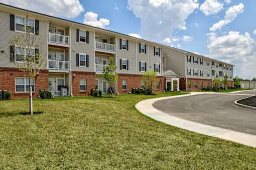 Apartment complex with a grassy area in front.