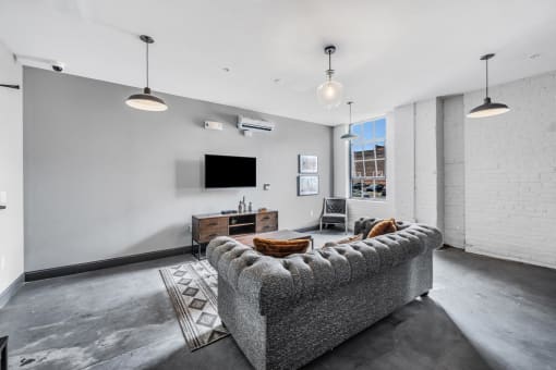 a living room with a couch and a tv in front of a window