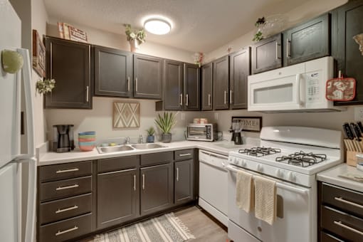 A kitchen with a white stove and black cabinets.