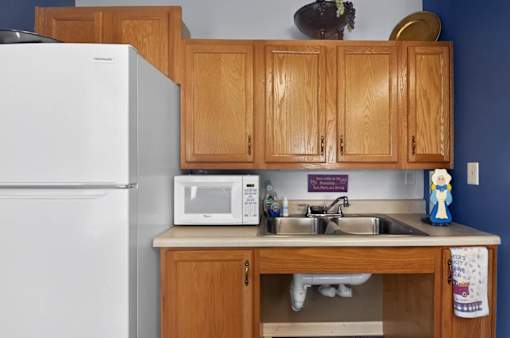 A kitchen with wooden cabinets and a white refrigerator.