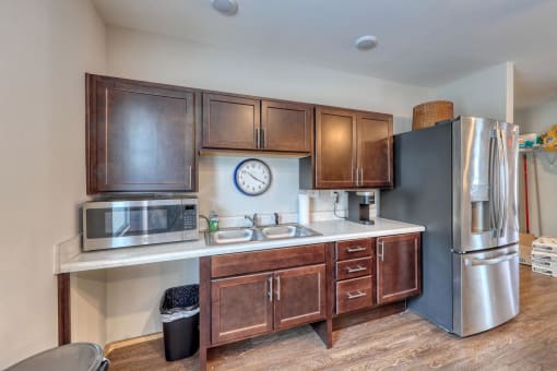 a kitchen with wooden cabinets and a clock on the wall