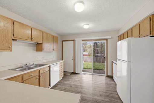 A kitchen with wooden cabinets and a white refrigerator.