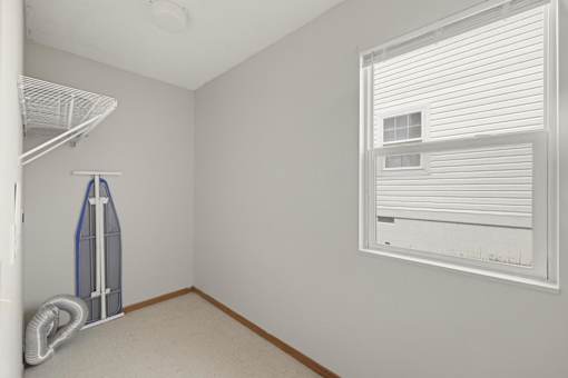 A room with a window and a wall-mounted fan.