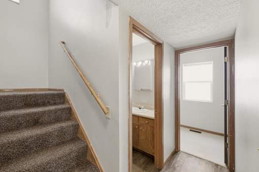 A bathroom with a sink and mirror is visible from the stairs.
