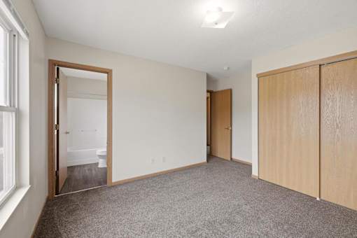 A room with a carpeted floor and a wooden door.
