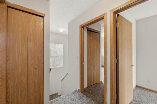 A room with a wooden door and a carpeted floor.