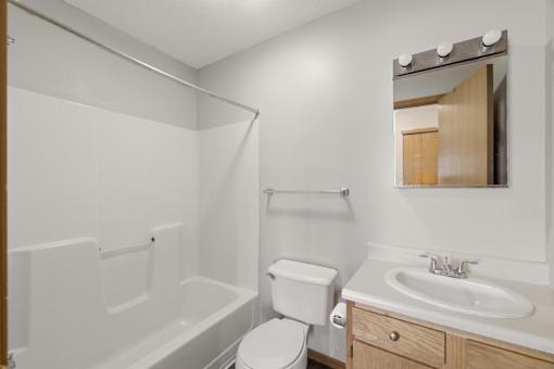 A white bathroom with a toilet, sink, and bathtub.