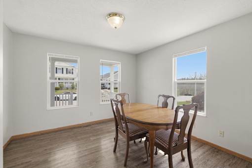 A dining room with a wooden table and chairs.
